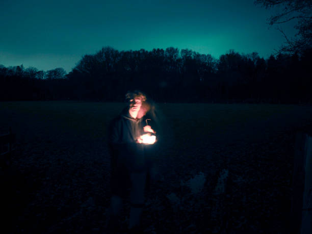 istock Young man in night holding a lantern 1156629568
