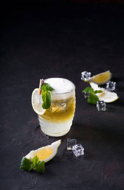 istock Moscow Mule Cocktail on a dark background. Cold drink, Layered white and yellow with vodka, spicy ginger beer, and lime juice. Selective focus.Cocktail card 1156631402