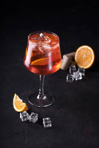 istock Stylish alcoholic Spritz trendy cocktail with orange slice on black background. Classic italian aperol 1156631415