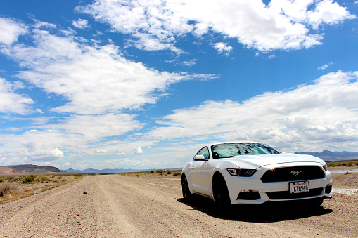 A shot of a white Ford Mustang taken by the side of a dirt road near Winnemucca in Nevada on a hot hot day.