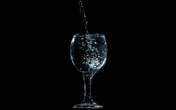 istock Pour water into glass on black background. 1156632806