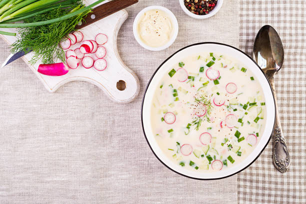新鮮なキュウリ、大根、ジャガイモ、ソーセージの冷たいスープにヨーグルトを入れました。伝統的なロシア料理 - オクロシュカ。夏の冷たいスープ。トップビュー。フラットレイ - soup cold russian culture traditional culture ストックフォトと画像