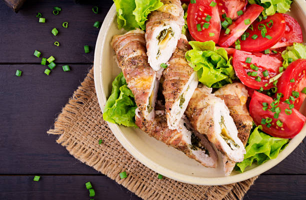 istock Delicious chicken rolls stuffed with cheese and spinach wrapped in strips of bacon. Top view 1156635931