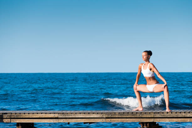 Woman exercising on pier.