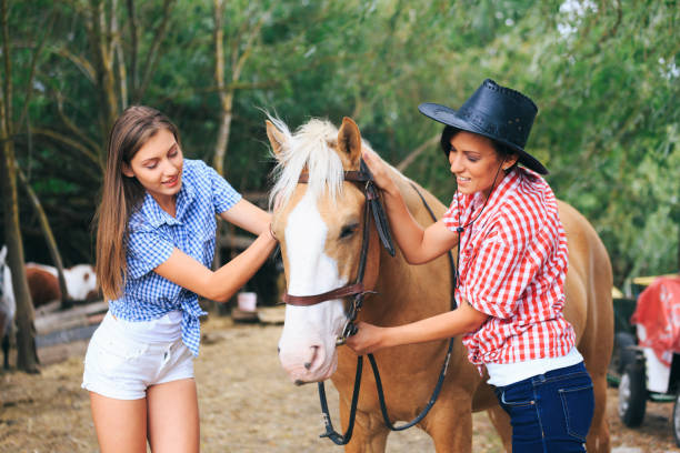 cowgirls che preparano un cavallo per un giro - shirt checked women wild west foto e immagini stock