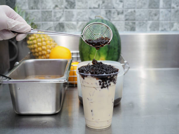 istock A plastic glass of refreshing iced fresh milk tea with small bubble (boba) or pearl on table. 1156636415