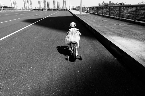 a young girl riding bicycle on the road