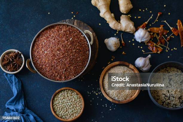 Varios Tipos De Arroz Y Granos Con Especias Sobre Fondo Azul Arroz Integral Y Arroz Silvestre Mezclado Foto de stock y más banco de imágenes de Abundancia