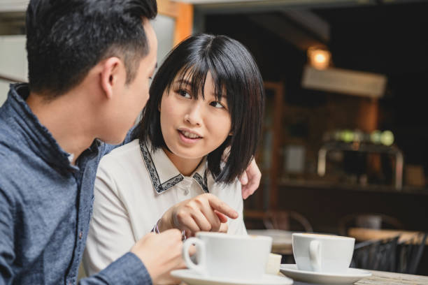 istock Young Chinese couple in discussion in cafe 1156641878