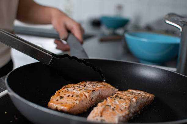 istock fried salmon cooking on the hob 1156642081