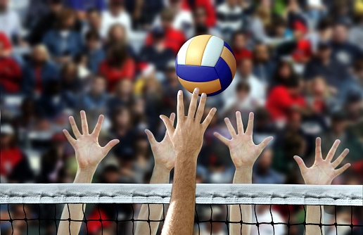 Pico de jugador de voleibol con las manos bloqueando sobre la red photo