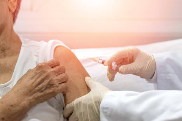 senior vaccination concept. elderly getting immune vaccine at arm for flu shot, pneumonia, and shingles(mmr) in hospital by nurse. doctor giving an injection to older people patient in clinic. - syringe healthcare and medicine vaccination nurse imagens e fotografias de stock