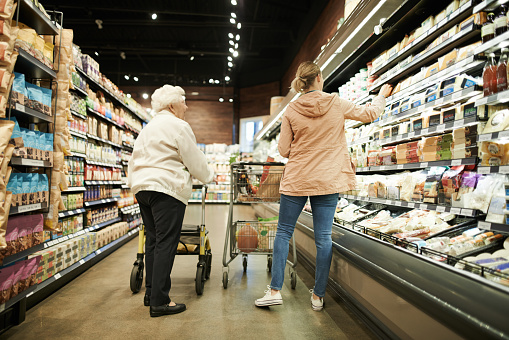 Shot of a senior woman shopping with her daughter at a grocery store