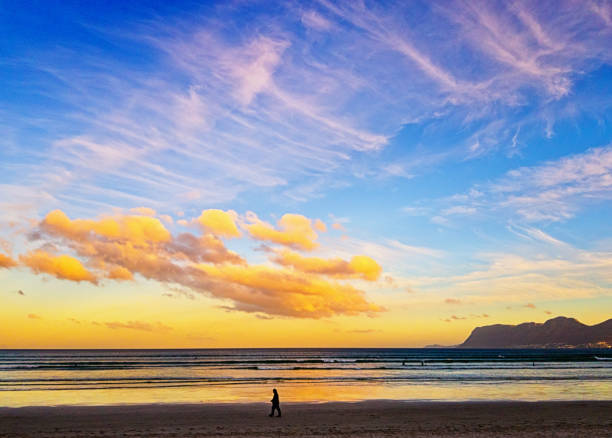 istock Beautiful ocean skys cape with lone silhouetted beach walker 1156645906