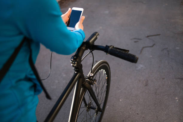 istock Senior sportswoman using her smart phone on bicycle 1156646626
