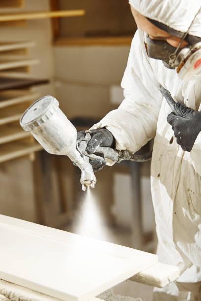 istock Man working with paint spray gun, airless spraying to wood 1156646833