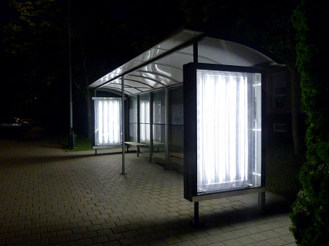 illuminated bus shelter at night in residential neighborhood