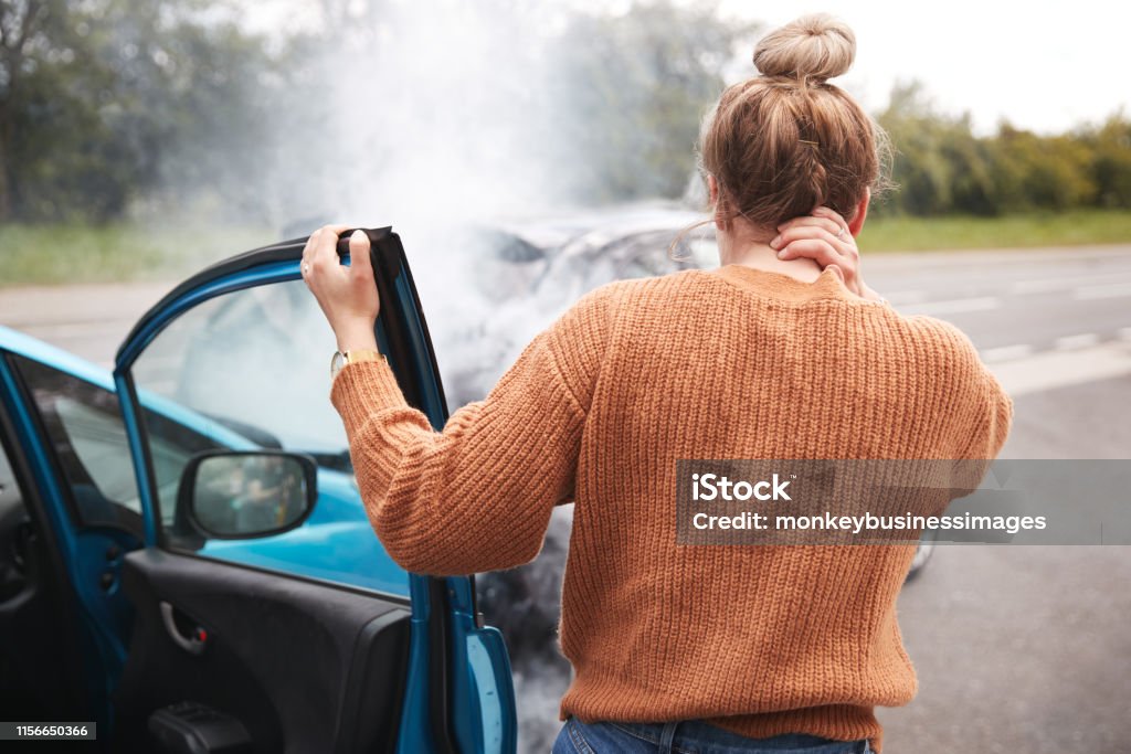 Achteraanzicht van de vrouwelijke automobilist met hoofdletsel om uit de auto na crash - Royalty-free Auto-ongeluk Stockfoto