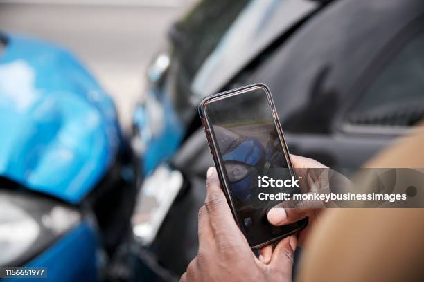 Male Motorist Involved In Car Accident Taking Picture Of Damage For Insurance Claim Stock Photo - Download Image Now