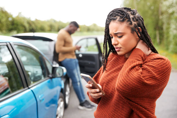 자동차 사고에 관련된 여성 운전자는 보험 회사 또는 복구 서비스를 호출 - fender bender 뉴스 사진 이미지