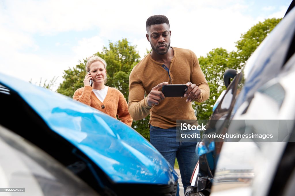 Male Motorist Involved In Car Accident Taking Picture Of Damage For Insurance Claim Car Accident Stock Photo
