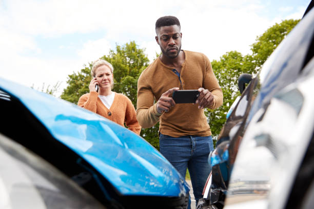 Male Motorist Involved In Car Accident Taking Picture Of Damage For Insurance Claim Male Motorist Involved In Car Accident Taking Picture Of Damage For Insurance Claim traffic accident photos stock pictures, royalty-free photos & images