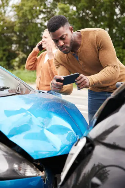 Photo of Male Motorist Involved In Car Accident Taking Picture Of Damage For Insurance Claim