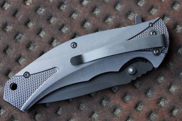 istock gray closed metal folding knife lies on a brown table 1156652962