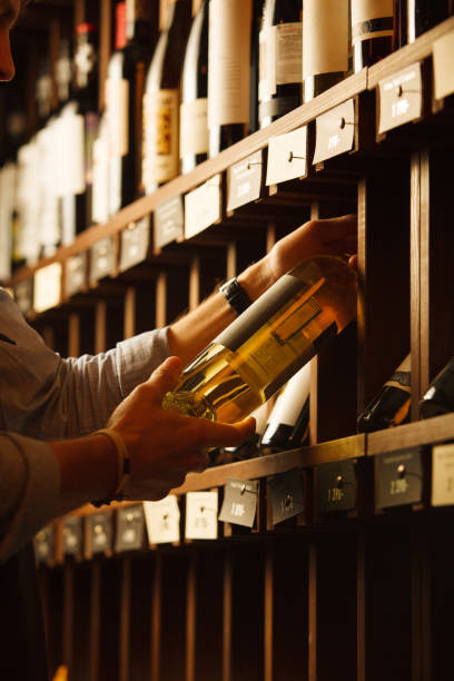 Expert in winemaking choose elite white wine in cellar.