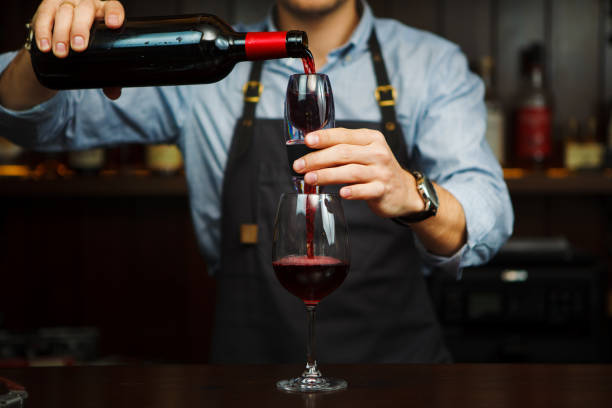 männlicher sommelier gießt rotwein durch belüfter ins glas. - decanter wine wineglass red wine stock-fotos und bilder