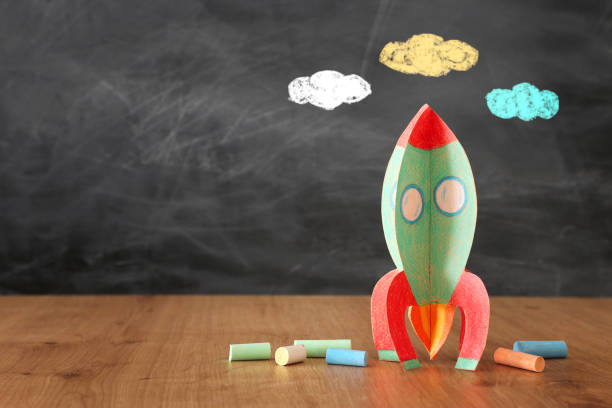 istock education and back to school concept. cardboard rocket and chalks in front of classroom blackboard 1156655204