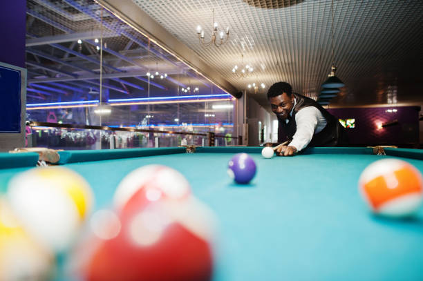 junge stattliche afrikanische mann trägt weißes hemd, schwarze weste und fliege spielen pool billard. - setting the table sports clothing practicing success stock-fotos und bilder