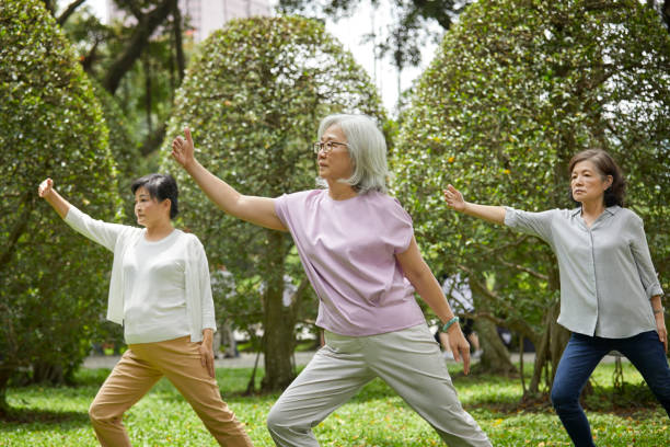 Women practicing martial arts with coach in park