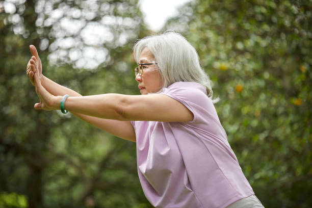 istock Senior woman practicing martial arts at park 1156656760