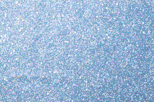 Holographic bright light blue glitter real texture background.