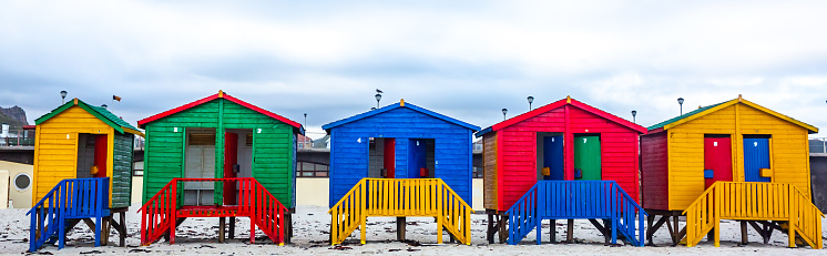 This pic shows colorful Muizenberg Beach houses used for changing  in  Cape Town city. These colorful houses are landmark of Cape town. The pic is taken in daytime and in March 2019.