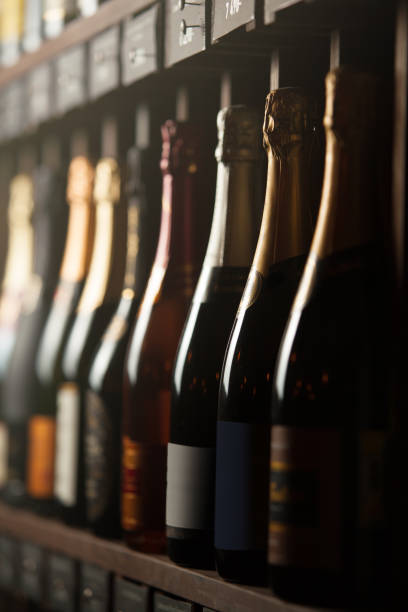 Underground cellar with elite sparkling wine on shelves, close up vertical photo. Background with different expensive alcoholic beverages