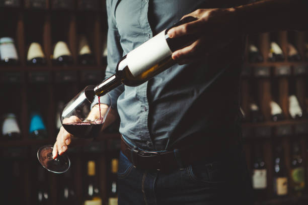 samiec sommelier wlewa czerwone wino do długich łodygi kieliszki do wina, strzał z bliska. kelner z butelką napoju alkoholowego. - wine decanter red restaurant zdjęcia i obrazy z banku zdjęć