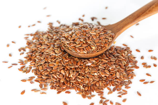 istock Brown flax seed in spoon on white background. 1156659085
