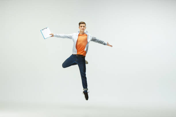 istock Man working at office and jumping isolated on studio background 1156659994