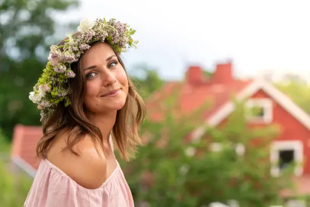 A Swedish woman on midsummer also known as midsommar in Sweden. She is wearing a traditional homemade flower crown to celebrate.