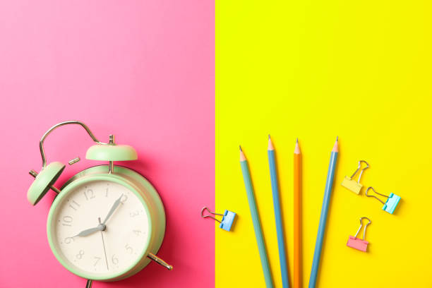 istock Composition with alarm clock, pencils and clips on two tone background, space for text 1156662092