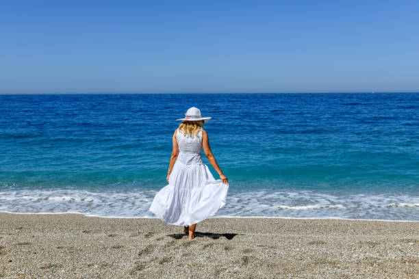 istock Woman walking on the beach. 1156662263