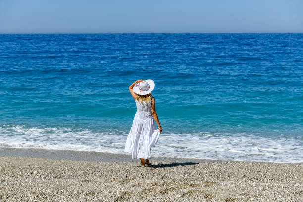 istock Woman walking on the beach. 1156662685