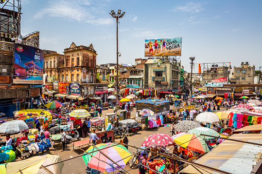 This pic shows aerial view of busy and Chaotic streets of Old Delhi in India. Street shops and their colorful umbrella can be seen in the pics. People are doing street shopping in the pic. The pic is taken in may 2019 in day time.