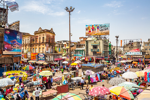 This pic shows aerial view of busy and Chaotic streets of Old Delhi in India. Street shops and their colorful umbrella can be seen in the pics. People are doing street shopping in the pic. The pic is taken in may 2019 in day time.