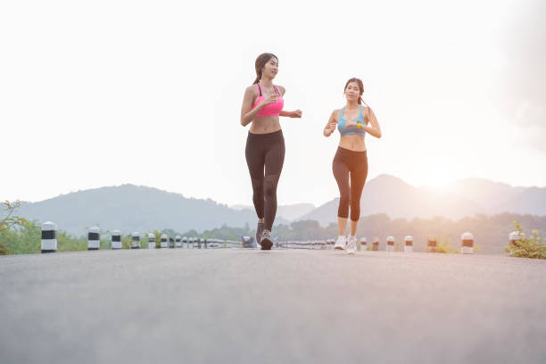 istock two ladies jogging on the road in the evening 1156664936