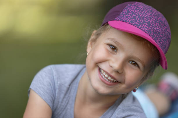 Child driving go-cart as hobby. Wearing a cap with pink shade. Focus on girl