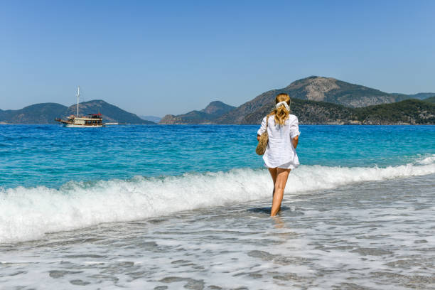 istock Woman walking on the beach. 1156665288