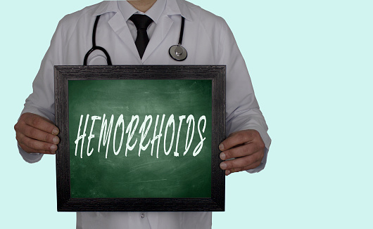 doctor holding blackboard hemorrhoids